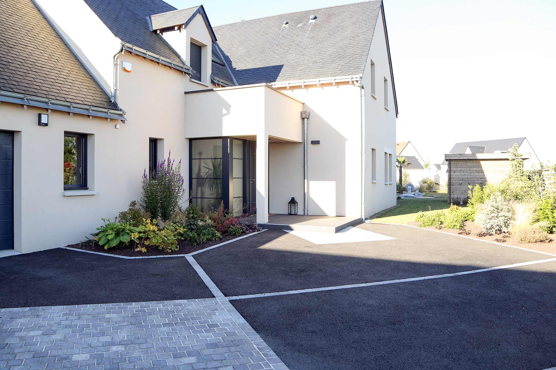 Serrault Jardins, paysagiste crée des accès de garage en enrobé noir.